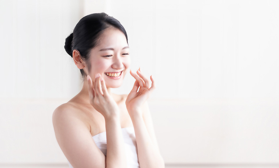 顔に触れる女性の写真