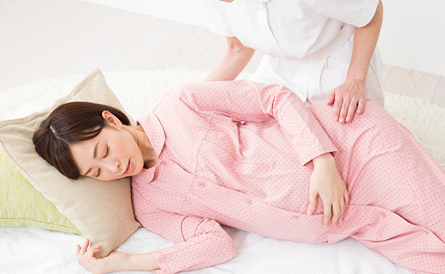 横になっている妊婦の写真